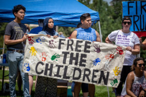 People marching behind a banner that says Free the Children