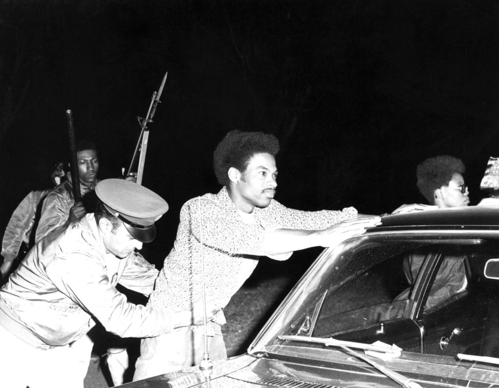 Black and white photo of a black man getting arrested in 1971