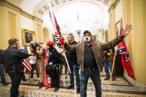 Man during the storming of the capitol holding the confederate flag