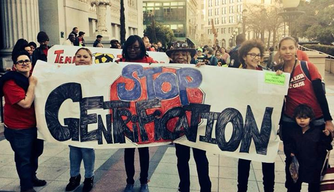 Women holding a banner that says Stop Gentrification