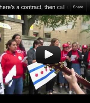 Video thumbnail image shows a group of people wearing red tshirts and holding up a variety of signs