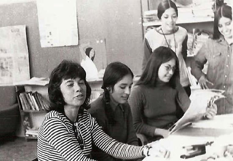 Photograph of Beita Martinez seated at a table, alongside her are other staffers of El Grito del Norte.