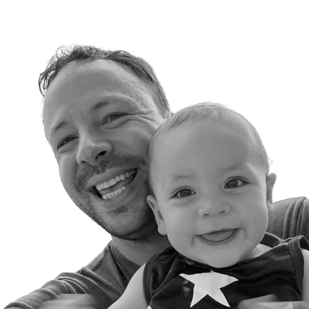 Black and White photo of Matt and his baby smiling