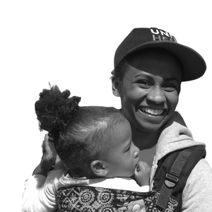 Black and white photo of Stephanie Greenlea smiling and holder her child in her arms