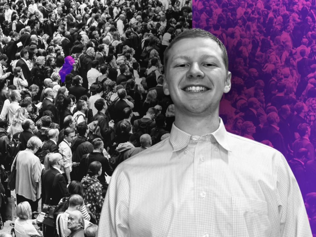 A smiling clean-cut young white man in a white shirt- Aaron Bushnell- superimposed on an image of a crowd. Half the crowd is in black-and-white and half in violet duotone, with a lone violet figure on tha black-and-white side.