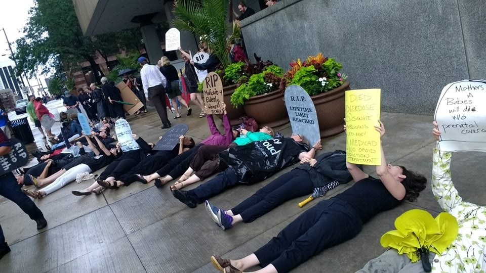 People participating in a "die in" holding up signs