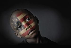 Photograph of a young black boy with the american flag projected onto his face