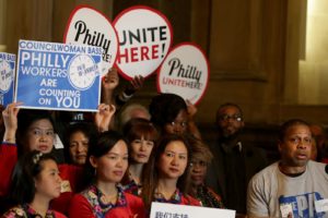 People holding up signs that say Philly Workers are Counting on You