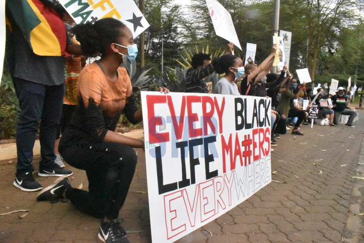 Photo of a group holding up a banner that says Every Black Life Matters