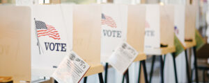 Photo of the booths in a voting location with signs on them that say Vote