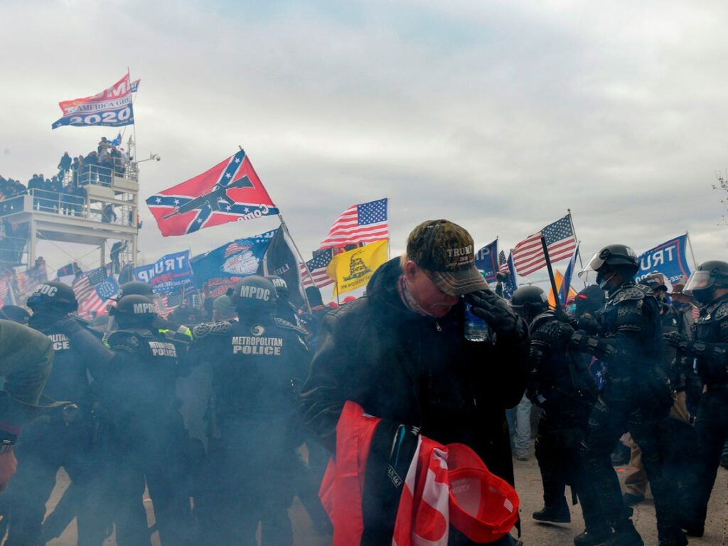 Men at a protest with the rebel flat and confederacy flag