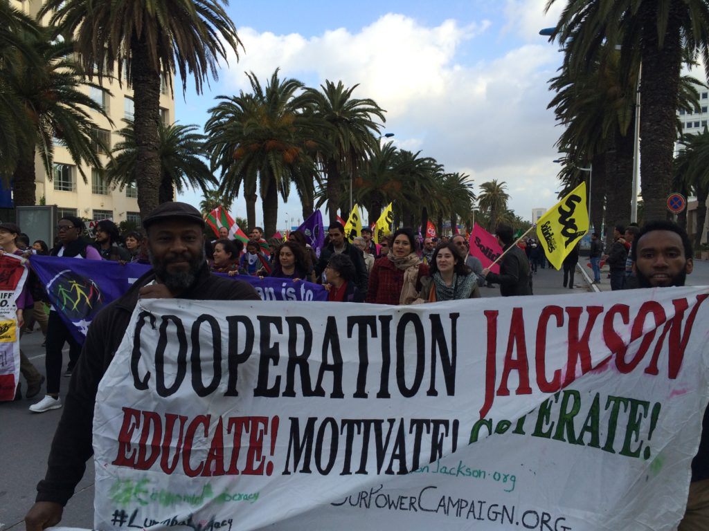 People marching with a banner that says Cooperation Jackson