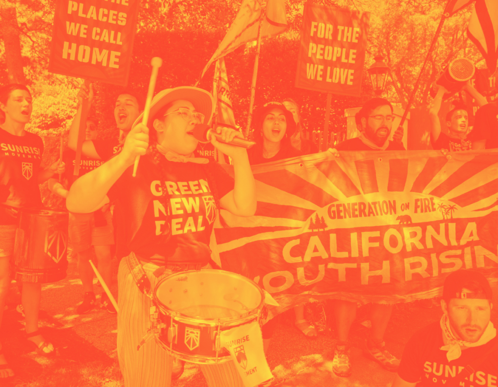 Foreground, woman with drum and microphone, wearing Green New Deal t-shirt. Next to and behind her, people singing. Banner reading "Generation of Fire: California Youth Rising."