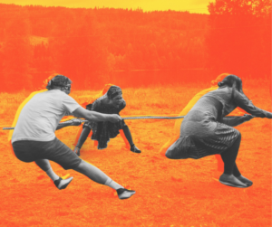 two people play tug of war, one person yells on in encouragement